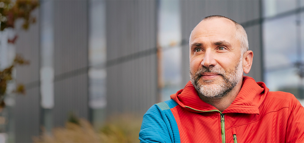 Dragos 坐在戶外，微笑著看向一旁。