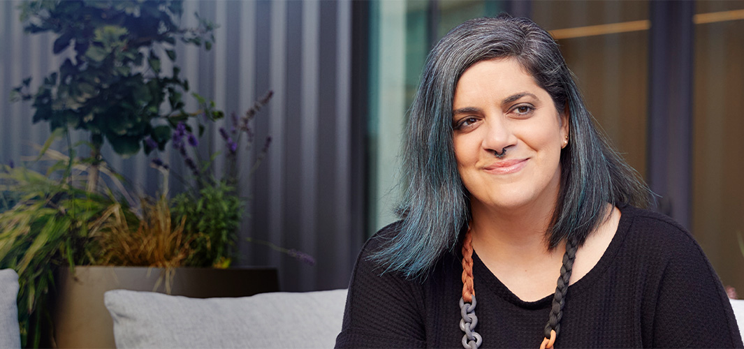 Jo 坐在室內，微笑著看向一旁。