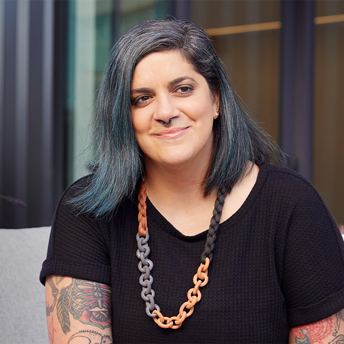 Jo 坐在室內，微笑著看向一旁。