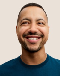 Portrait of a smiling Apple Retail team member with short dark hair and a beard.