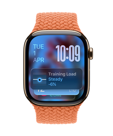 Apple Watch in Gold Titanium with a braided strap in Tangerine, face shows date at top left, time with stacked numerals at top right, Training Load widget at bottom, all in translucent Liquid Glass
