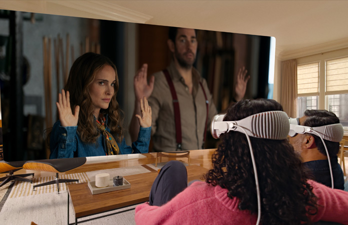 Apple Vision Proを装着した2人がソファに並んで座り、部屋いっぱいに広がるスクリーンに映し出される「ファウンテン・オブ・ユース 神秘の泉を探せ」を観ている