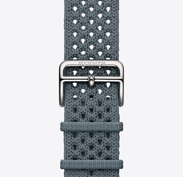 حزام Néo&nbsp;Tricot لساعة Apple&nbsp;Watch&nbsp;Hermès&nbsp;Series&nbsp;11‏، لون bleu&nbsp;gris (أزرق رمادي)، نسيج محبوك من خيوط البولي أميد، فتحات تعديل في الوسط، نظام إغلاق بمشبك بلون فضي يحمل نقش Hermès‏