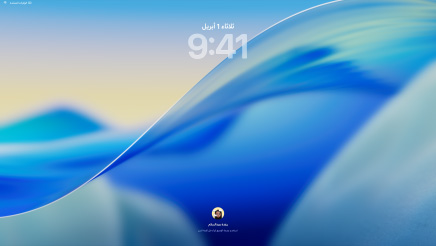 ثلاثة من موديلات Mac موجهة إلى الأمام ومعروضة في صف واحد، ويبعد الواحد منها عن الآخر قليلاً، في الجهة اليسرى جهاز MacBook Pro مقاس 16 إنش باللون الفضي يظهر على شاشته تطبيق الهاتف الذي يعرض جهات اتصال حديثة، وفي الوسط جهاز iMac مقاس 24 إنش باللون الأزرق تظهر على شاشته صورة لموجة متحركة وهي إحدى خلفيات نظام macOS Tahoe، وفي الجهة اليمنى جهاز MacBook Air مقاس 13 إنش بلون سماء الليل تعرض شاشته ميزة الباحث على سطح المكتب مع تصميم Liquid Glass لشريط الأيقونات وأدوات مختلفة مثل التقويم والساعة والطقس