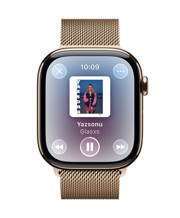 Milano Loop kayışa sahip Altın rengi Titanyum Apple Watch'un kadranında Apple Music’te oynatılan bir şarkı ve yarı saydam Liquid Glass denetimleri görünüyor