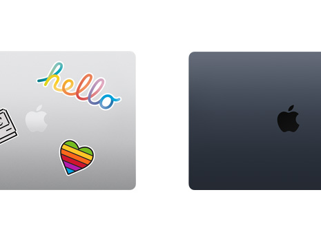 Vista de cima de dois portáteis Mac fechados, um com autocolantes.