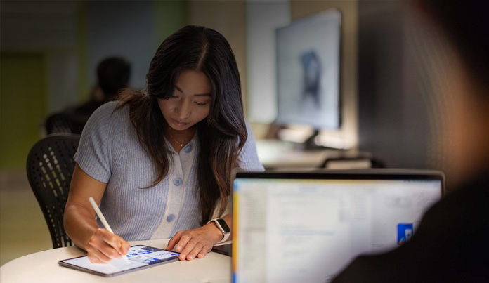 University student uses Apple Pencil to take notes on an iPad in a technology lab