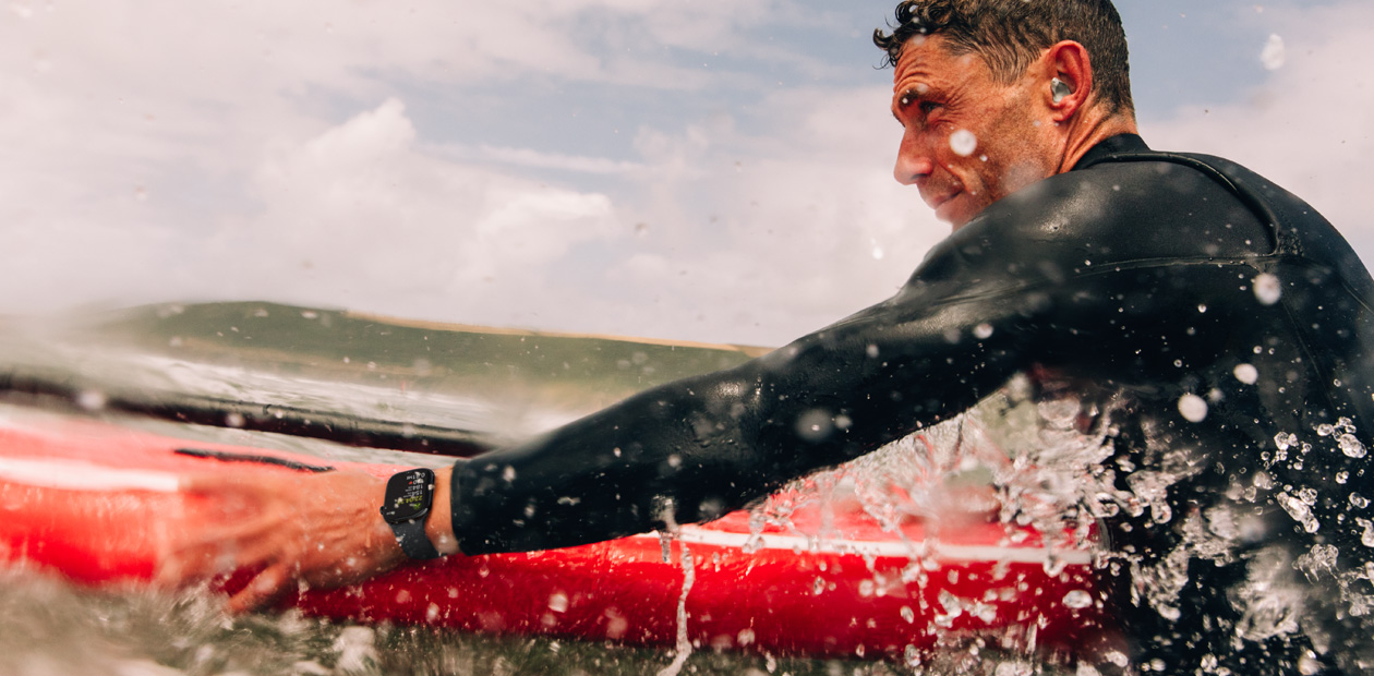 Homem surfando com o Apple Watch.