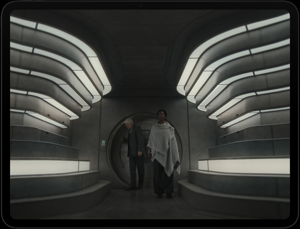 iPad Pro, display with image of 2 people entering a futuristic interior in the Apple TV+ series Silo.