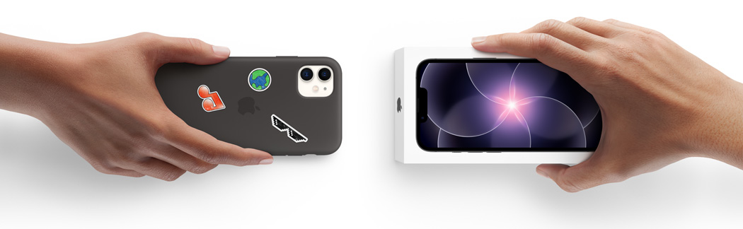 Una mano sostiene un iPhone 11 en una funda de silicón con stickers en la parte posterior y, al lado, una mano sostiene un nuevo iPhone 17e dentro de su caja para hacer el canje