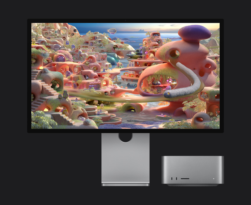 In a cartoon landscape on Studio Display XDR with Mac Studio tucked underneath, a worm-like creature appears to exit a tunnel and move across the screen